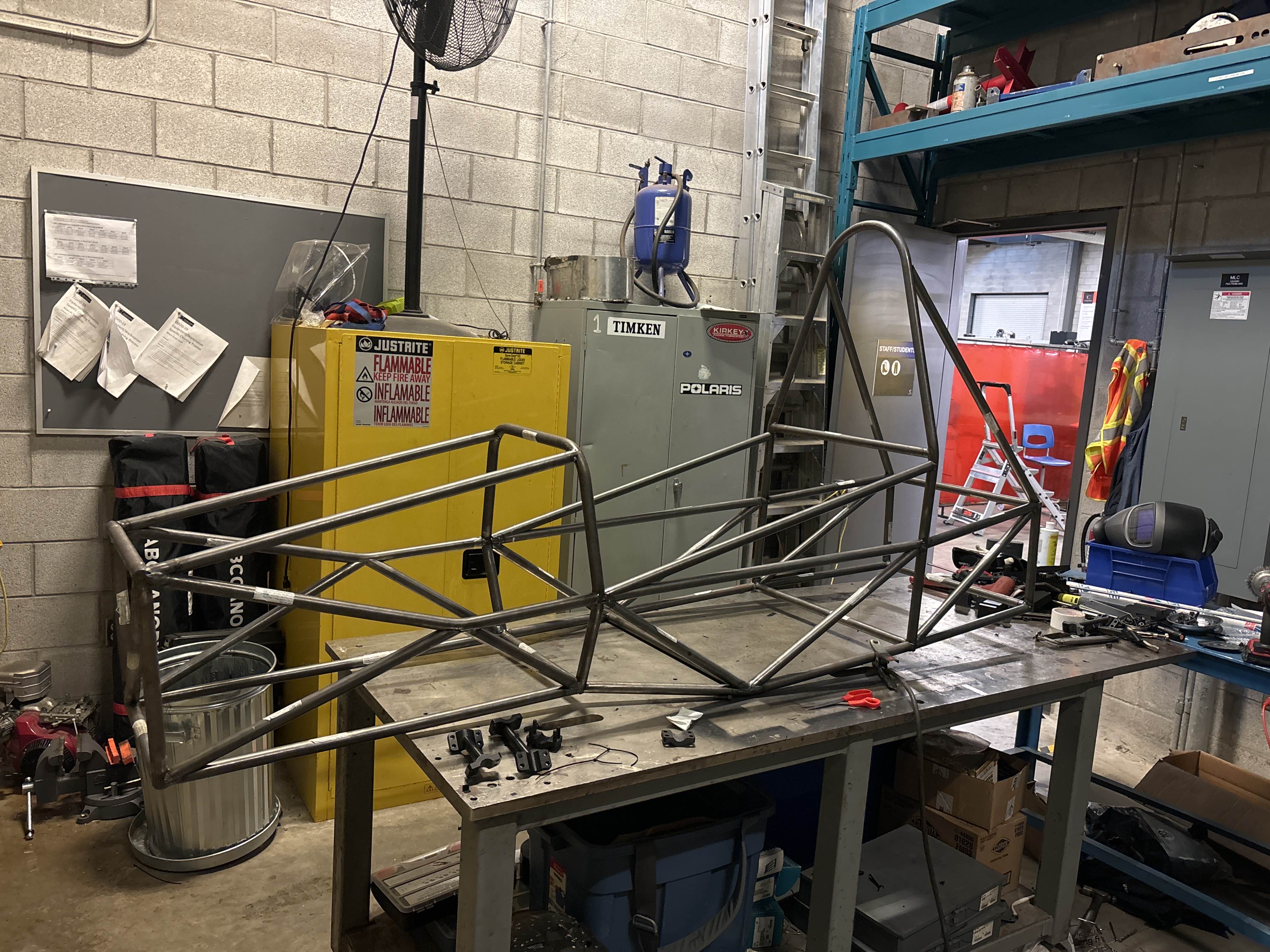 Students posing with the Conestoga race car chassis